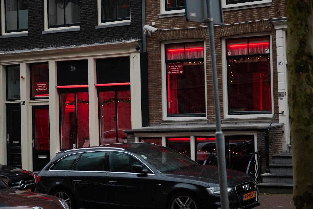 black sedan parked beside red building