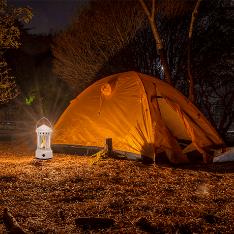 Aigostar energieeffiziente Campinglampe mit heller Beleuchtung neben einem Zelt im Dunkeln