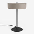 Moderne Studio Monton tafellamp met ronde beige kap en een slank zwart metalen voet