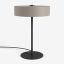 Moderne Tischlampe von Studio Monton mit rundem beigem Schirm und einem schlanken schwarzen Metallfuß