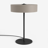 Moderne Studio Monton tafellamp met ronde beige kap en een slank zwart metalen voet