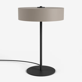 Moderne Tischlampe von Studio Monton mit rundem beigem Schirm und einem schlanken schwarzen Metallfuß
